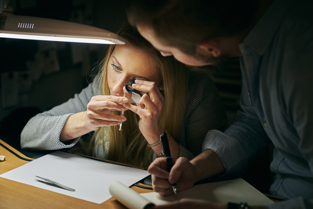 Gemmologische Prüfung eines Diamanten mit Lupe und Steinzange bei Uhren & Schmuck Schöller