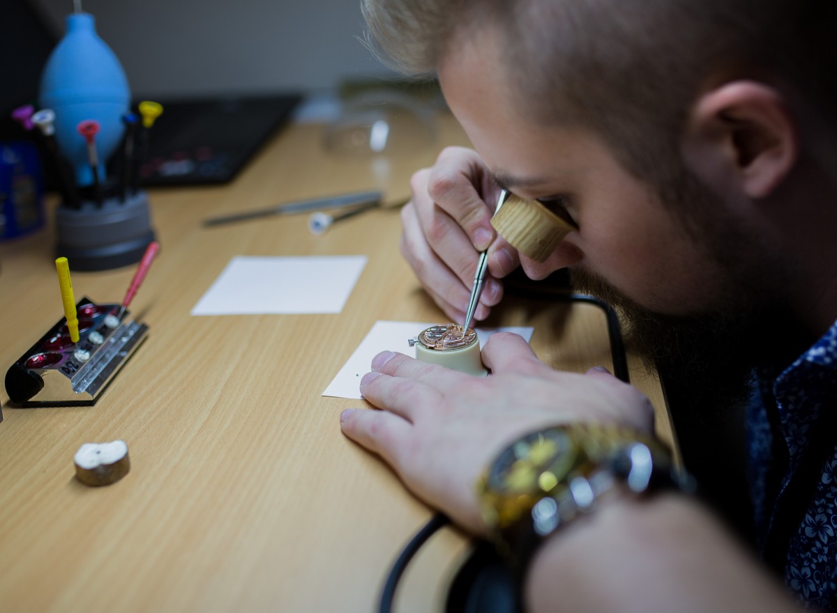 Uhrmachermeister am Werktisch der Fachwerkstätte von Uhren & Schmuck Schöller Reinigung, Reparatur und Umarbeitung in der hauseigenen Fachwerkstätte